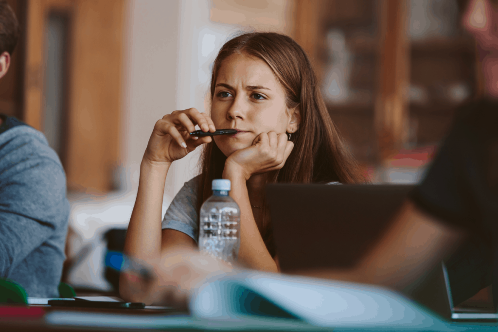 Tippek kezdő pedagógusoknak - Fiatal diáklány felelés közben gondolkozik.