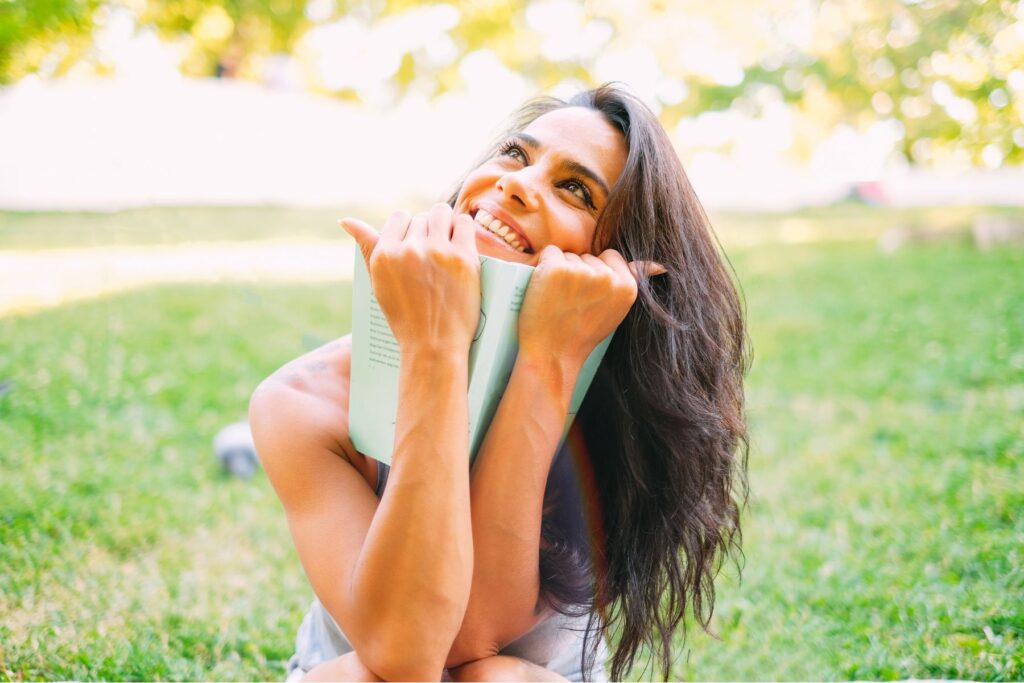 hálanapló - nő könyvvel a kezében mosolyog