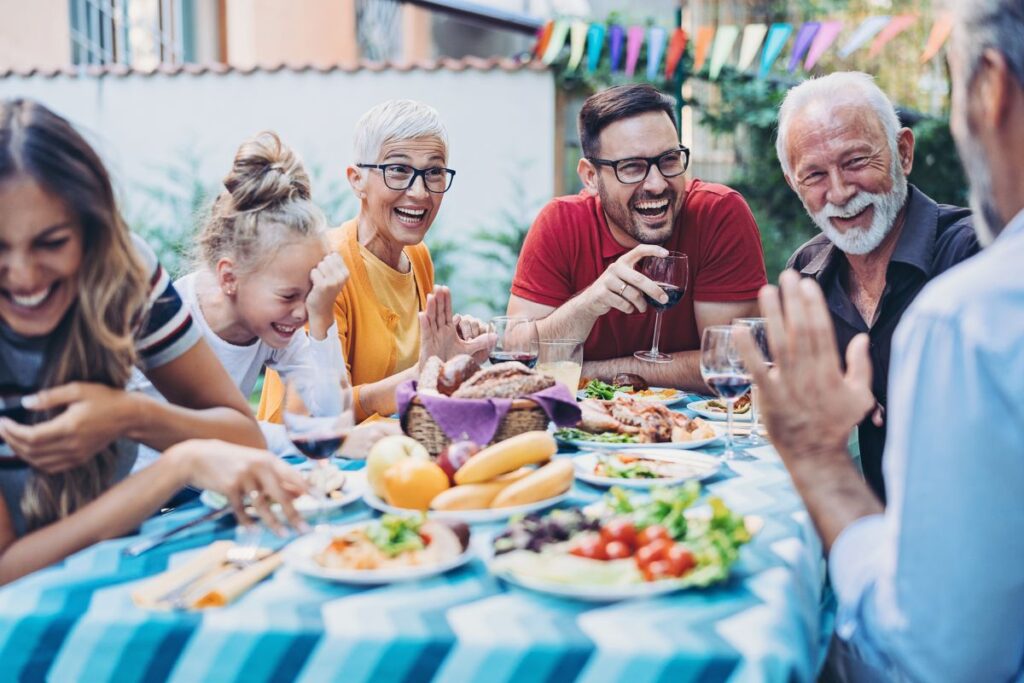 Egy nagy család egy asztalnál ül, beszélgetnek és nevetnek. - örökölt sors